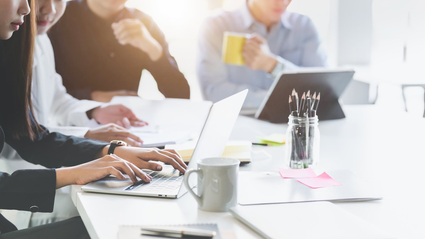 Faceless modern workers using gadgets in office